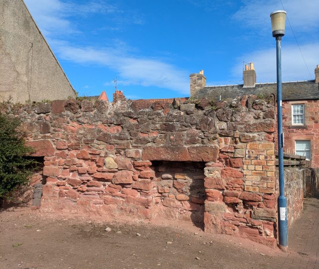 An old red sandstone wall with two fireplaces/